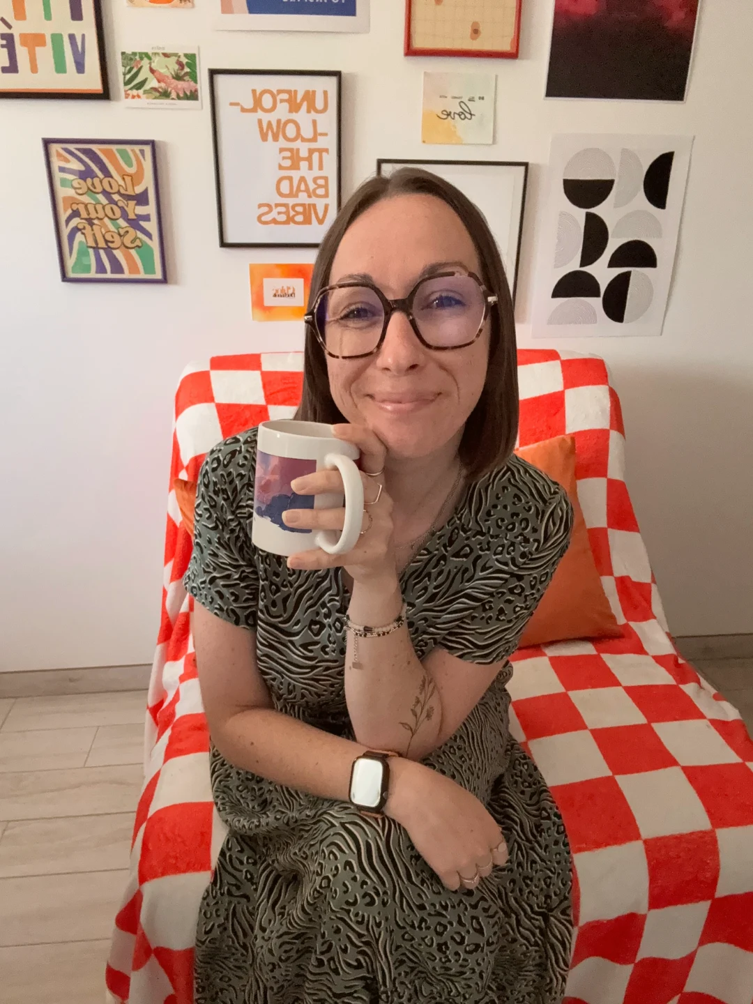 Chloé, ta coach, dans son fauteuil à damier orange, un mug à la main